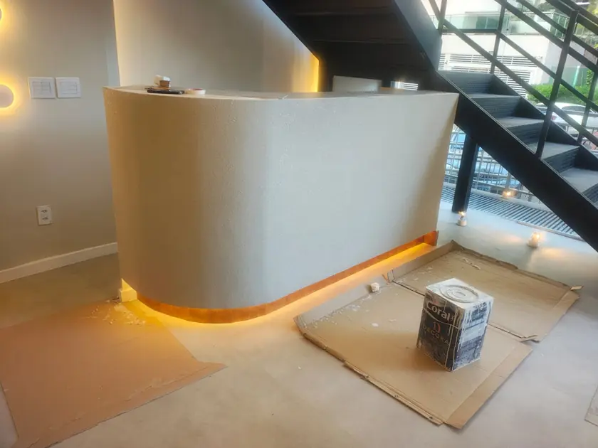 Balcão curvo com textura e fita de LED no rodapé